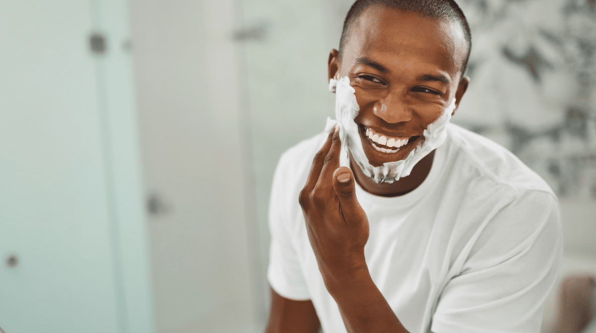Man using shaving cream to avoid razor burn on face