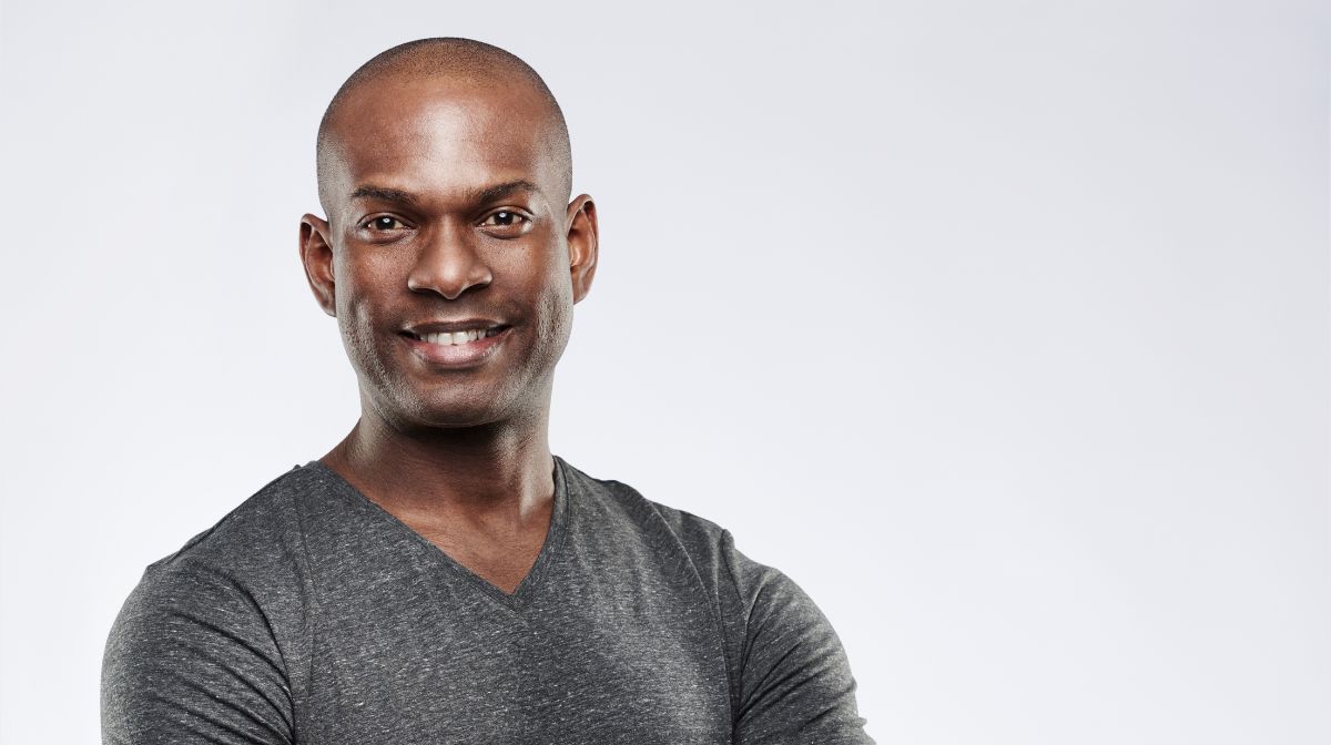 A smiling man with a shaved head in a grey t-shirt | Gillette UK