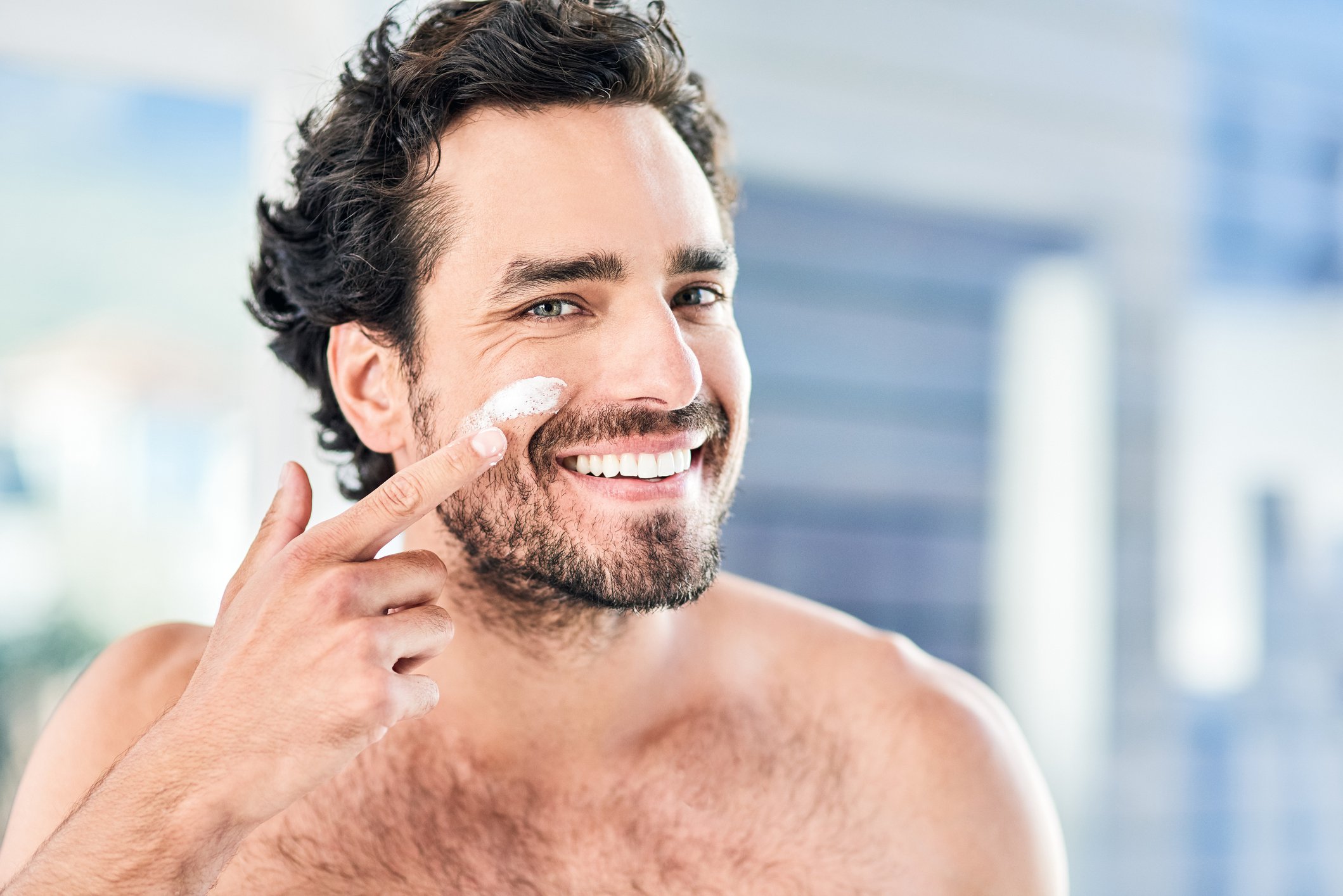 man with stubble beard moisturising face 