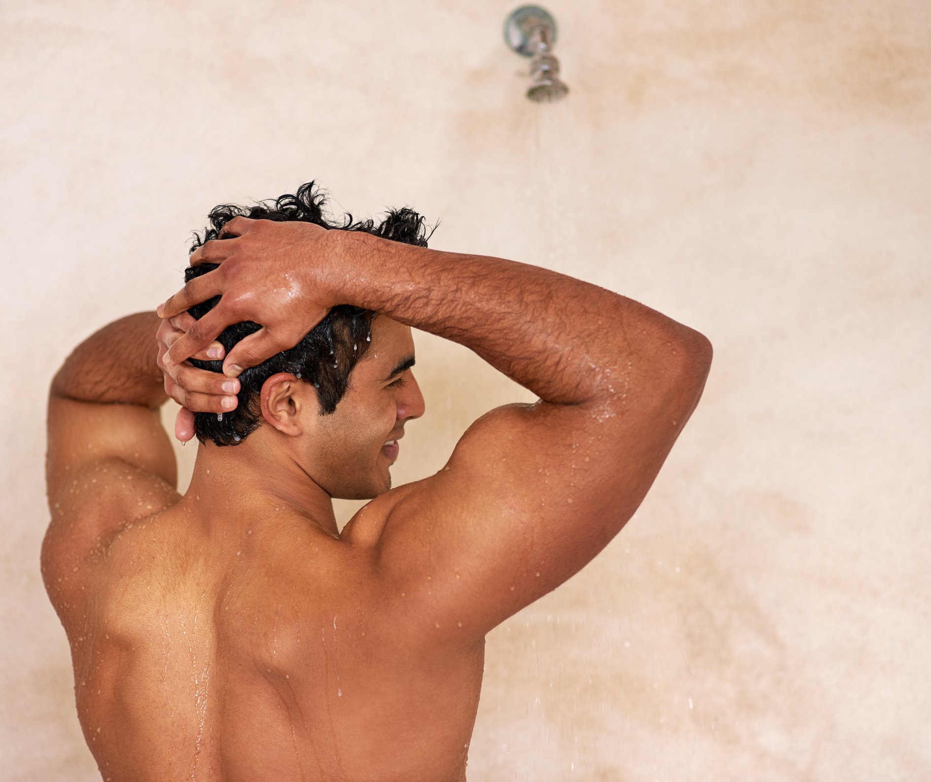 A man takes a warm shower to properly prep his hair and skin prior to starting intimate grooming and reduce the risk of experiencing razor bumps| Gillette UK