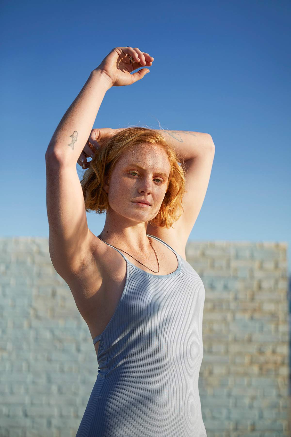 A woman wearing a lilac vest top raises her arms | Venus UK