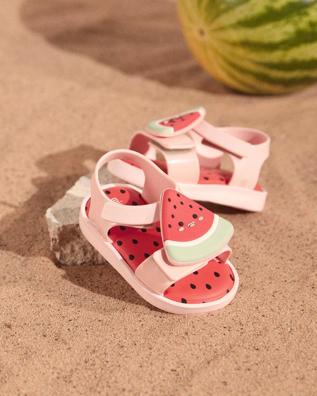 pink water melon sandals on the sand 