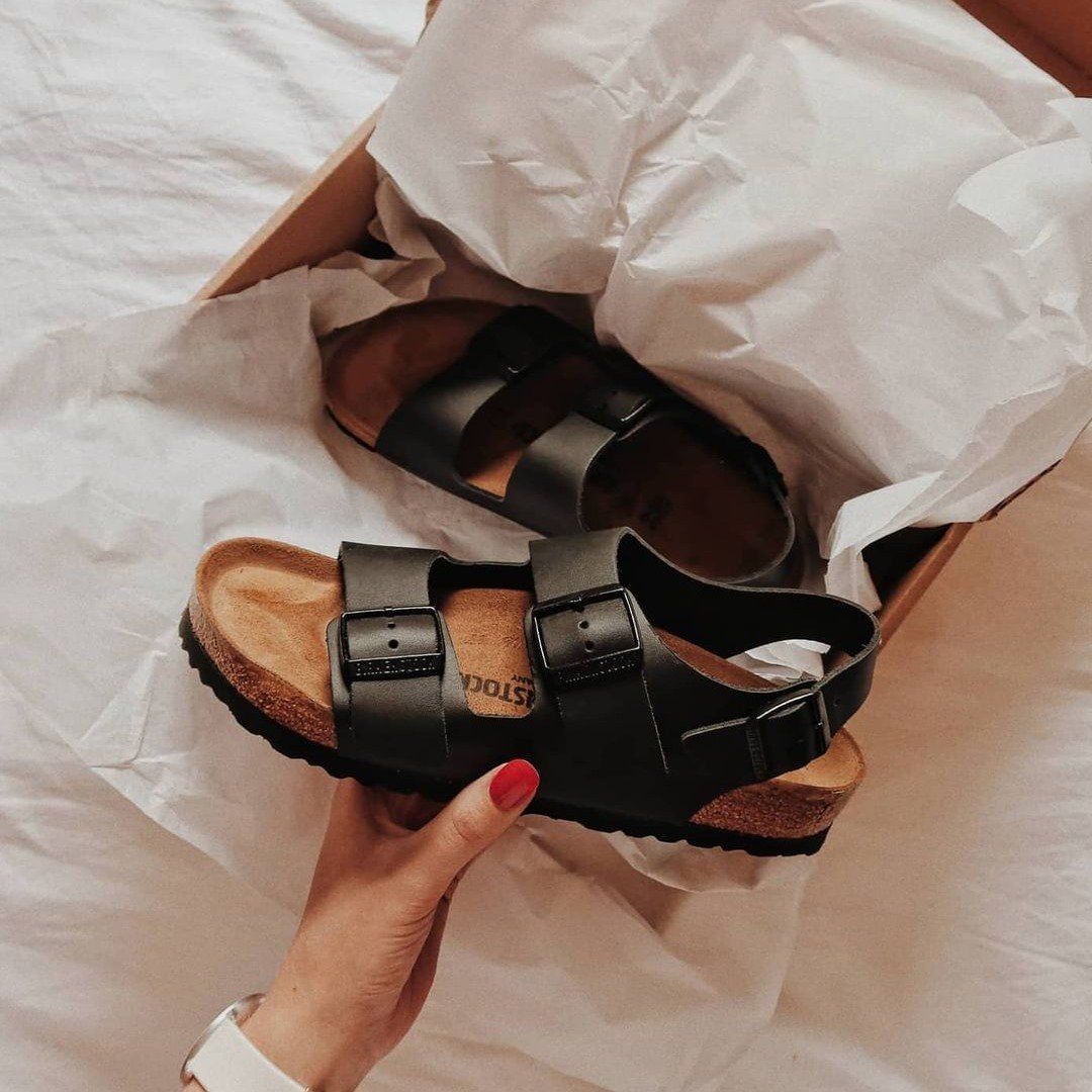 woman holding birkenstock sandal 