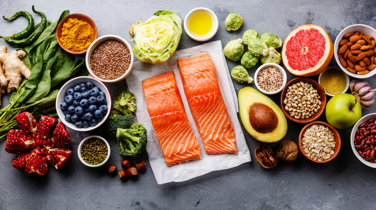 range of foods high in omega-3 on a table, including salmon, avocado and walnuts