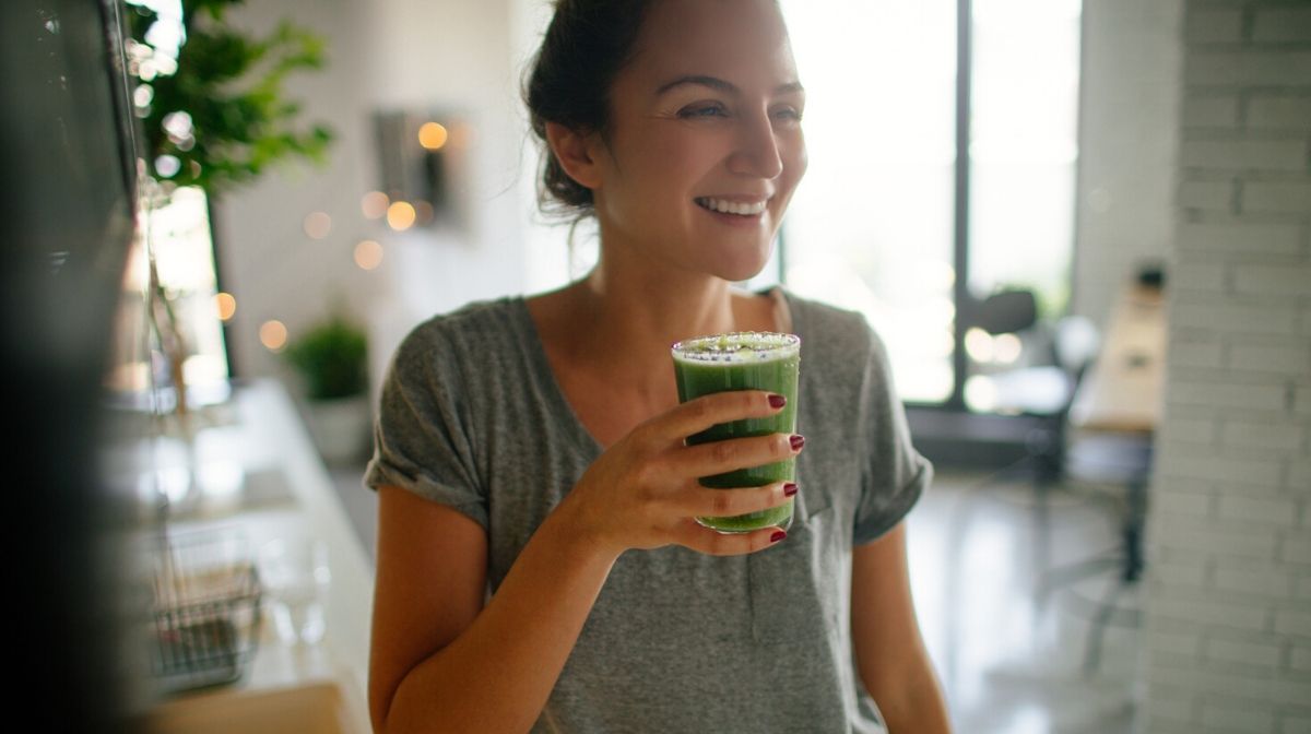 woman drinking a smoothie made with collagen peptides powder