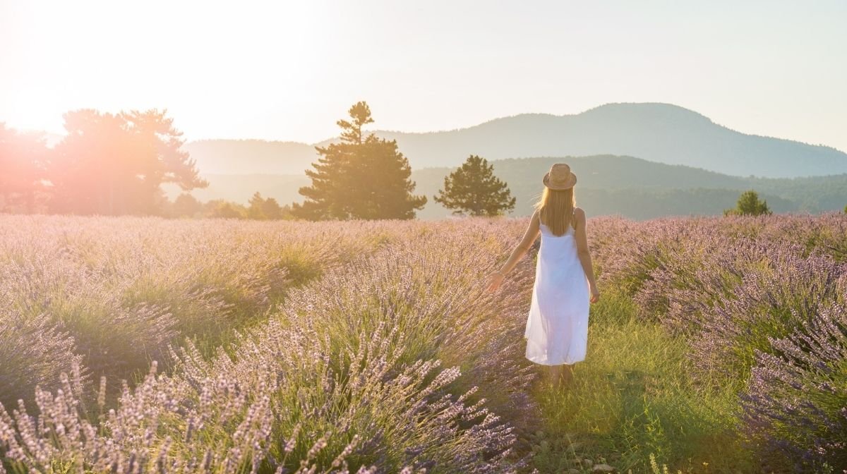 woman walking through a field of flowers