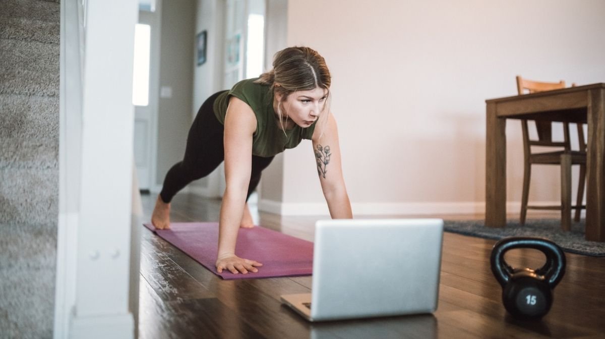 woman doing an online workout class at home