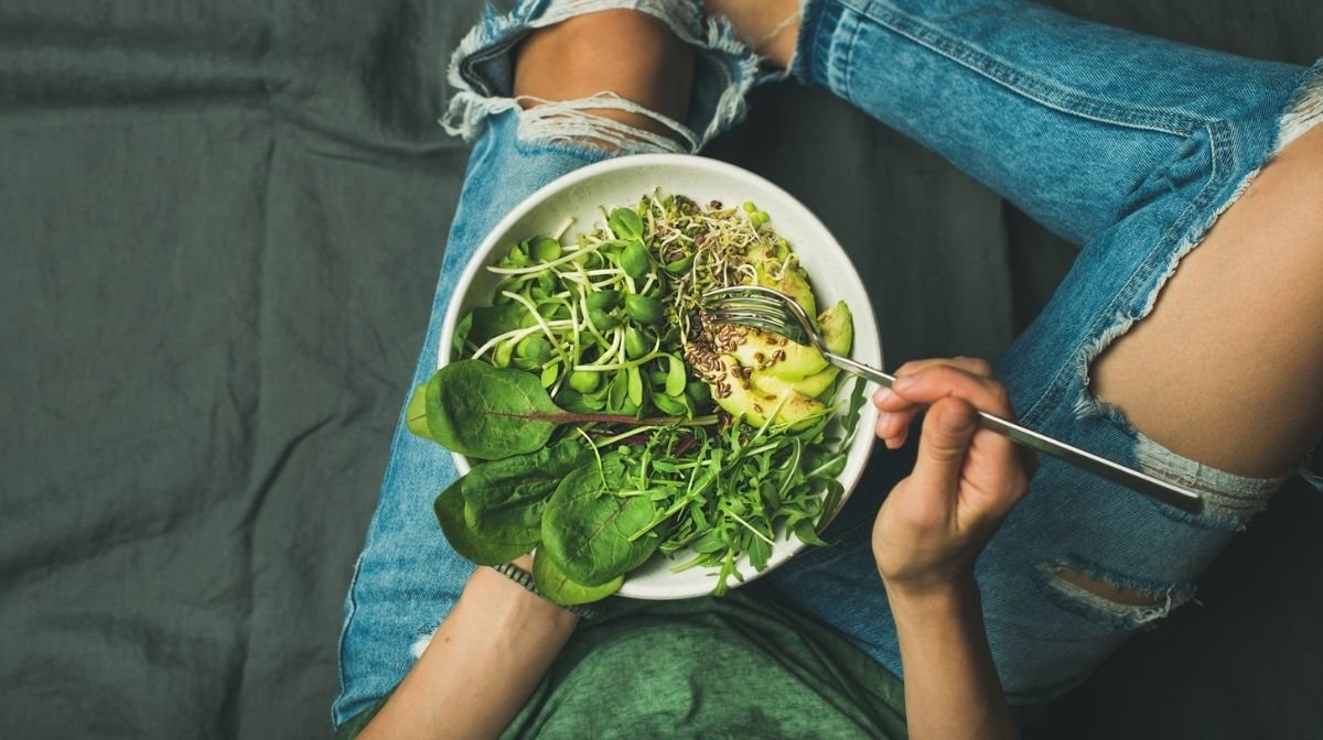 woman eating a bowl of healthy vegan food