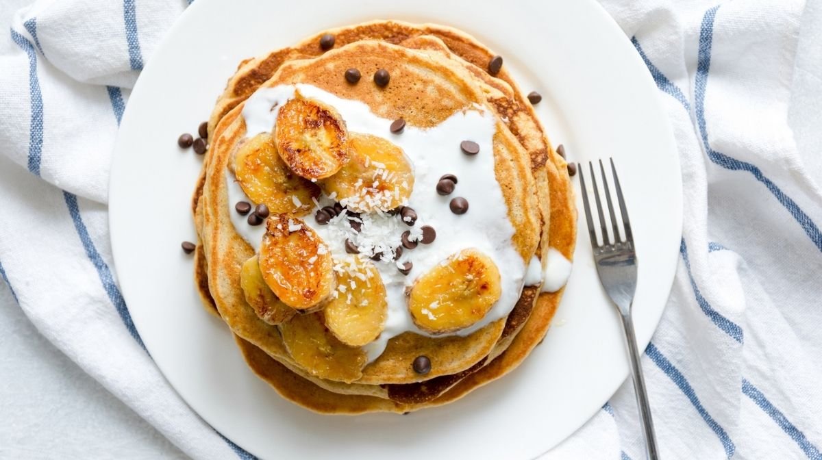 stack of pancakes with yoghurt, fruit and chocolate chips