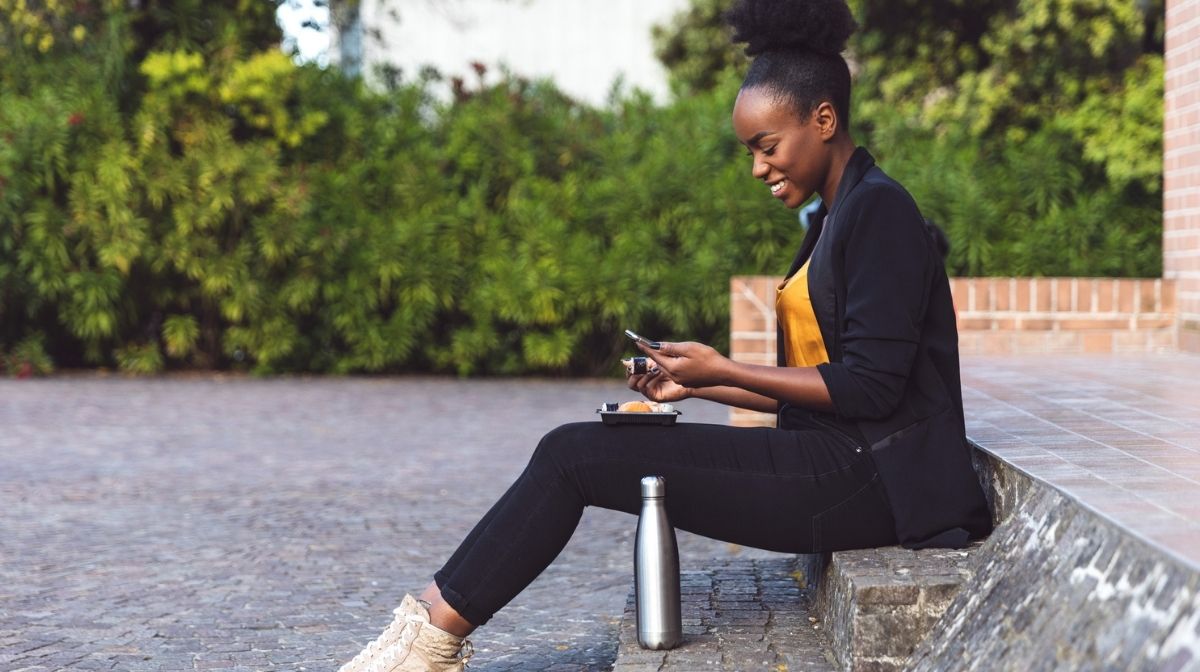 woman with water bottle checking her phone