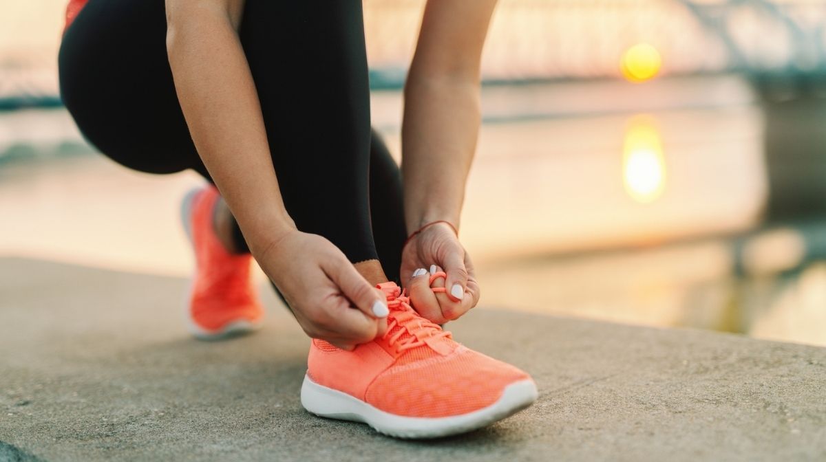 woman tying running shoes before exercise
