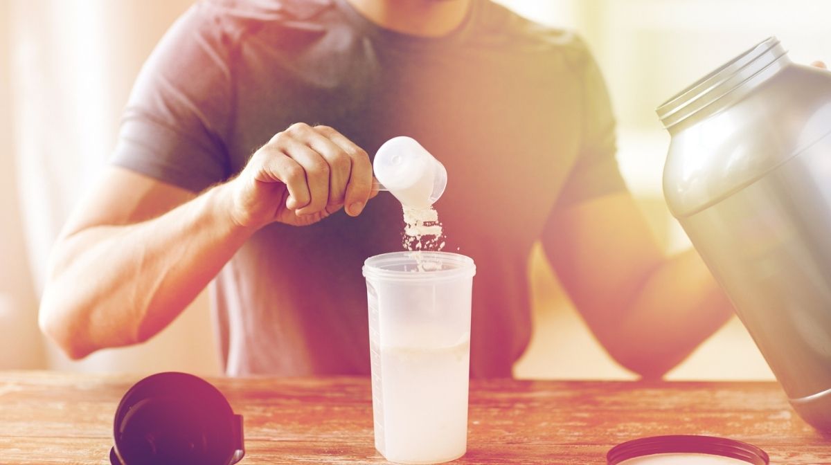 man making protein shake with protein powder