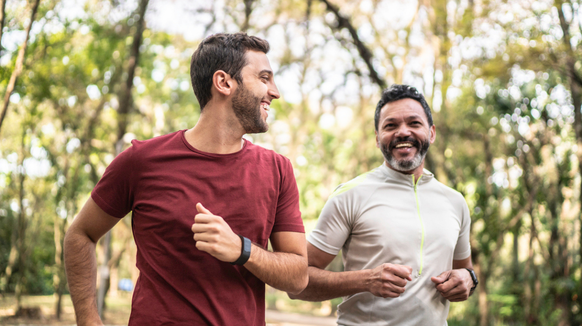 two men jogging outdoors together smiling