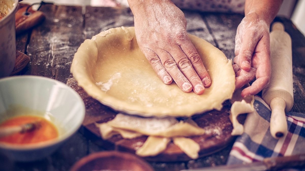 hand lining baking tin with vegan pie crust