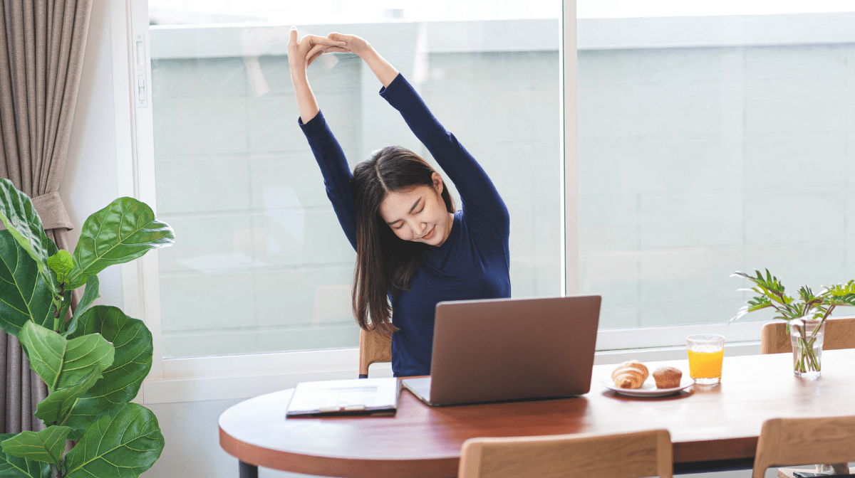 asian woman stretching at her desk