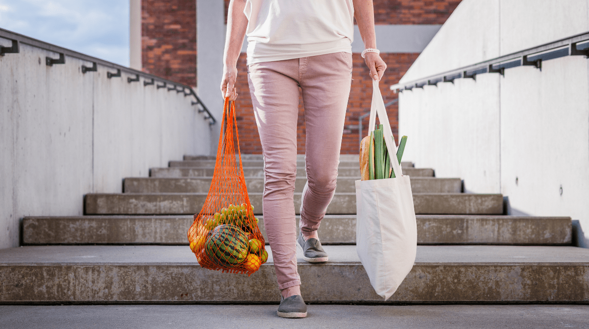 woman carrying reusable shopping bags with groceries for sustainable living