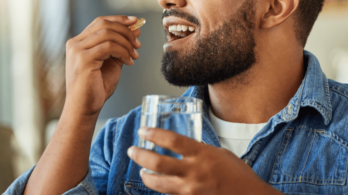 Man taking medication with a glass of water