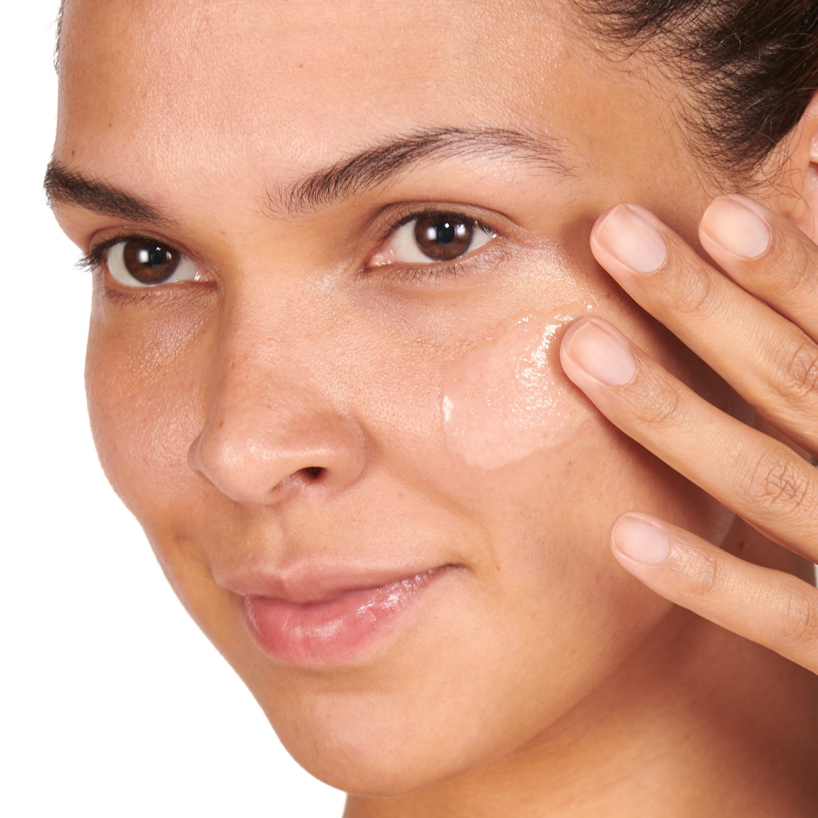 Woman applying serum to cheekbone.