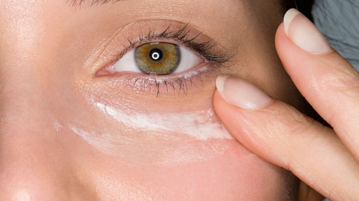 Close up of woman applying eye cream in order to get rid of puffy eyes