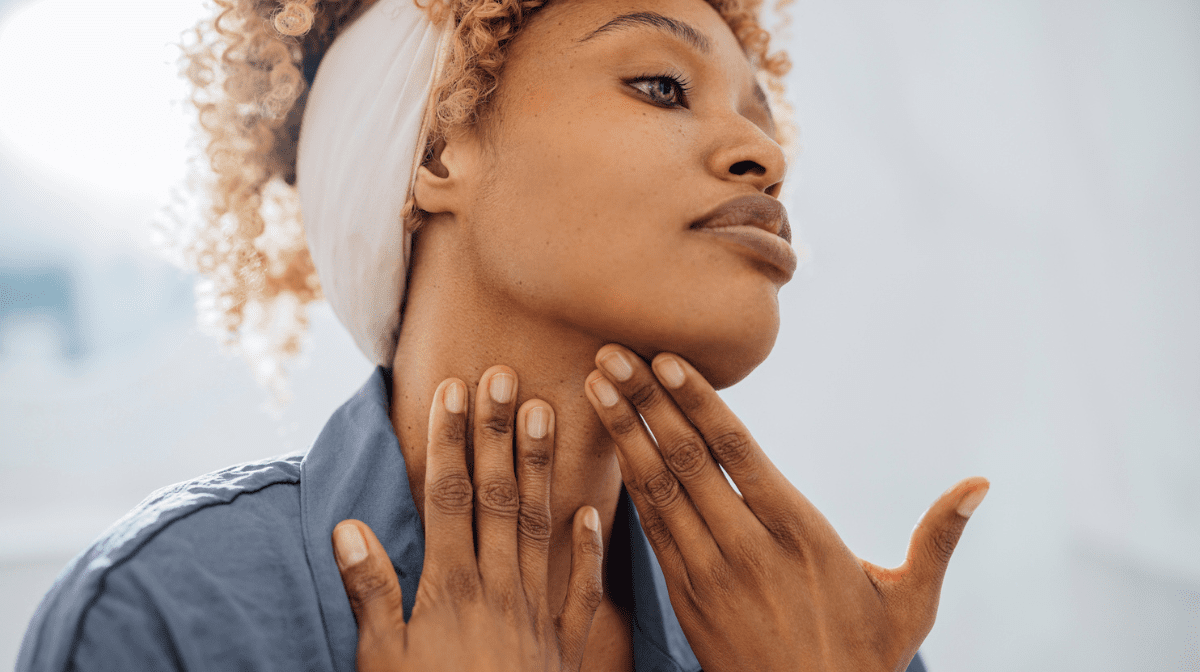 Woman massaging cream into neck