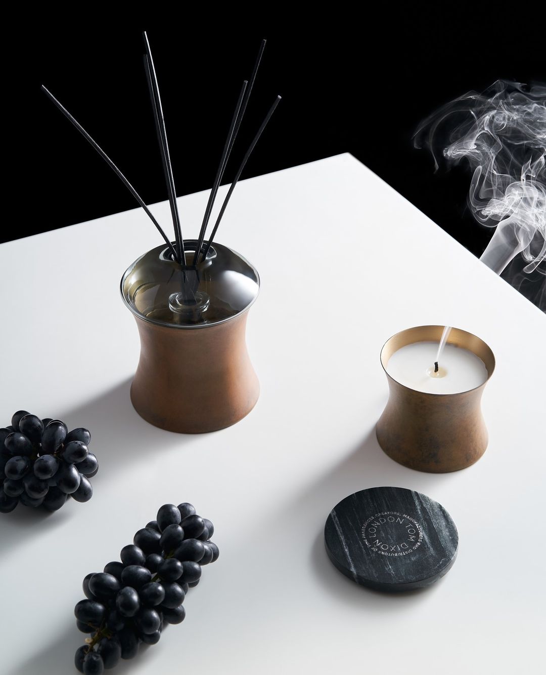 A Tom Dixon lit candle and diffuser