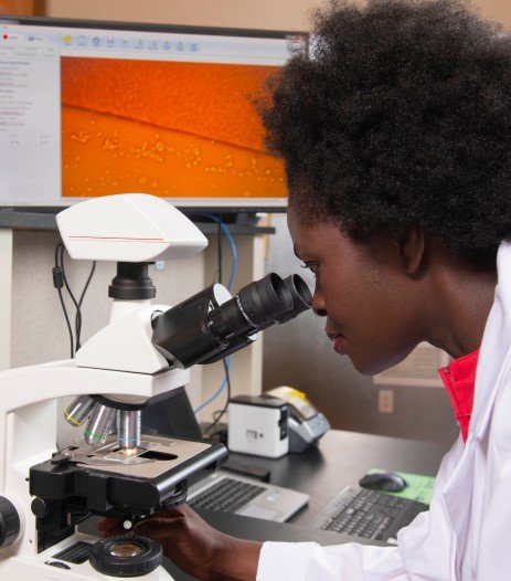 Abena Antwi looking through a microscope