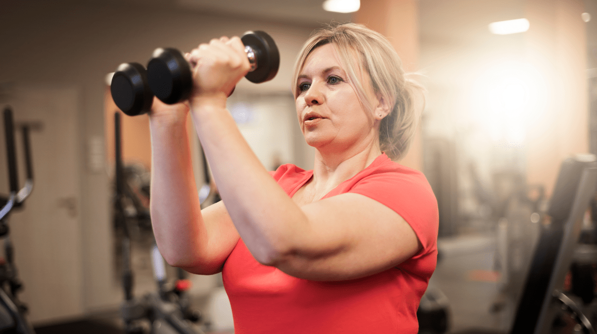 A woman in the gym using weights, demonstrating how to improve strength
