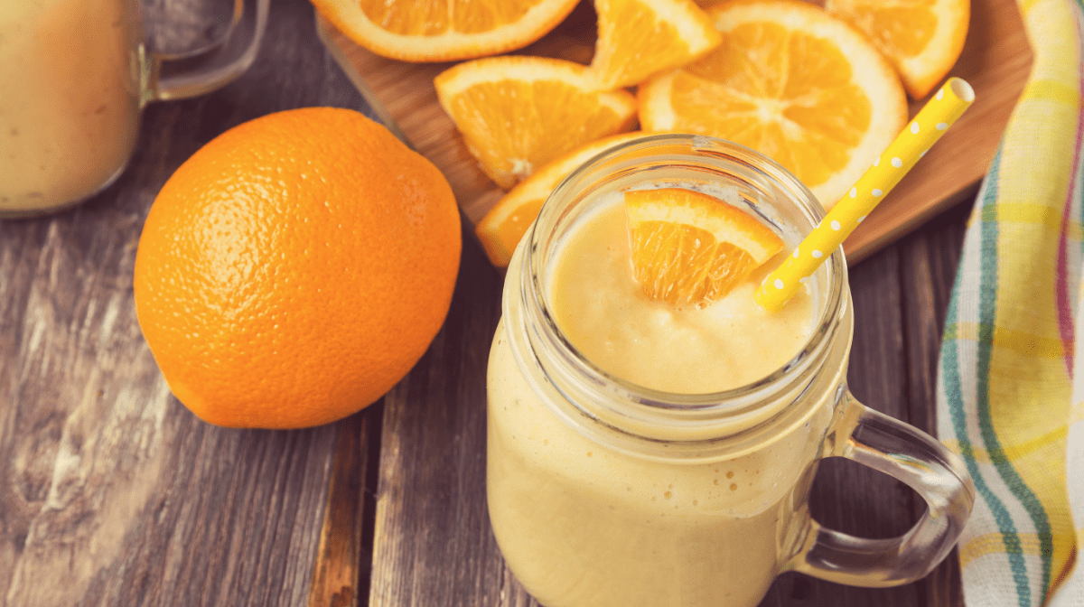 Immunity boosting smoothie on a table, surrounded by oranges - a fruit known for its high concentration of Vitamin C and antioxidants.