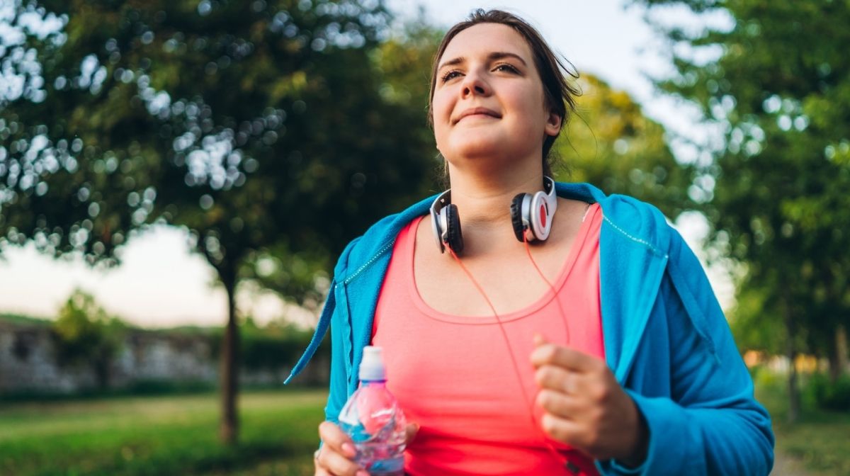 woman running outdoors with weights