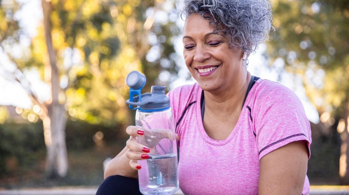 woman drinking water during a break from exercise