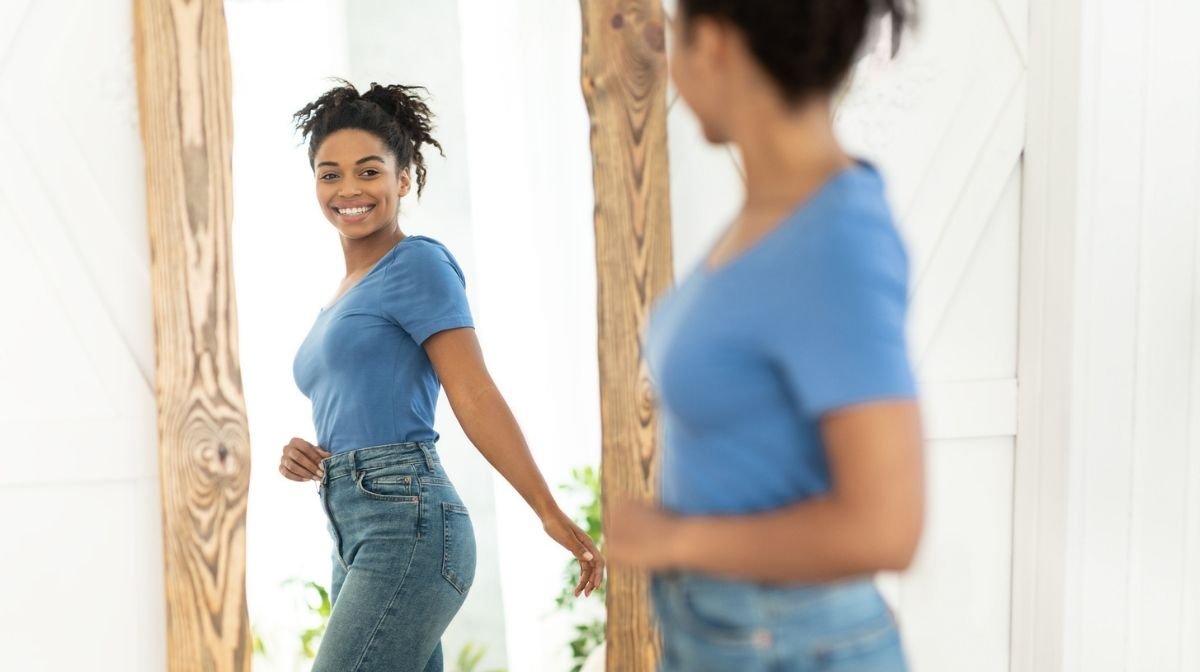 smiling woman looking at herself in mirror