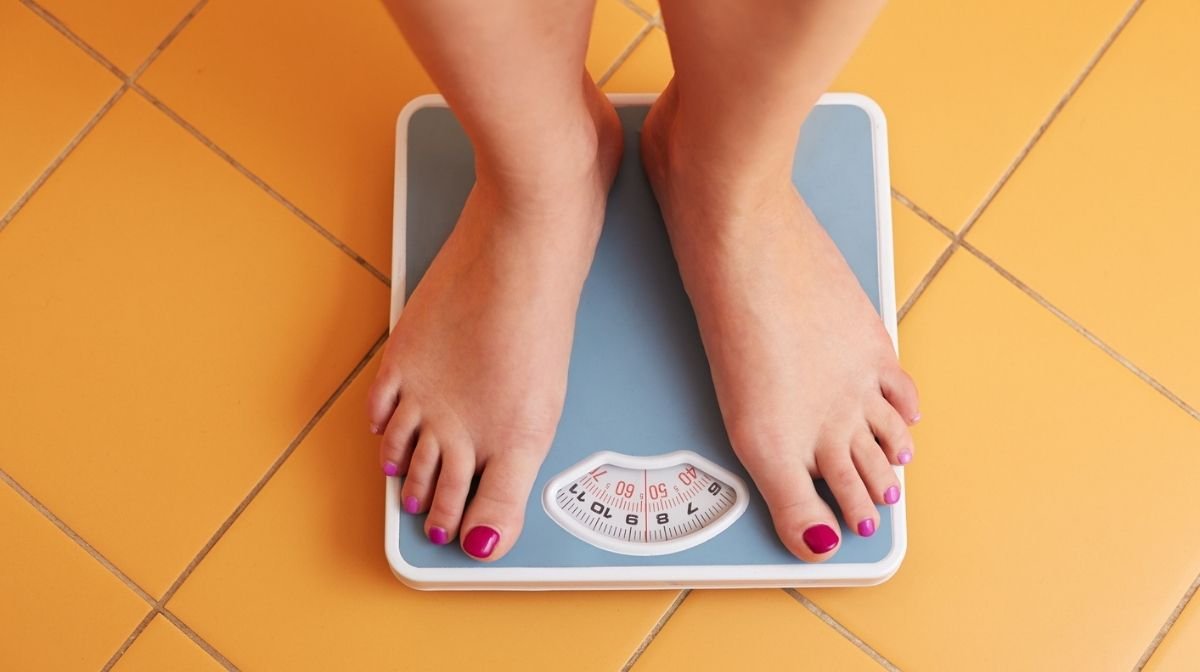 woman standing on bathroom scales