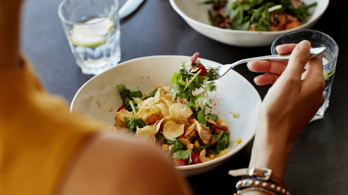 A woman eating a healthy low-calorie salad.