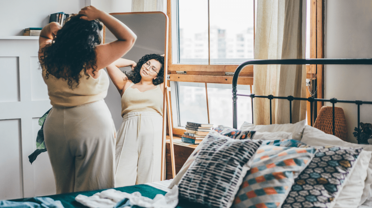 A woman looking at herself in the mirror. 