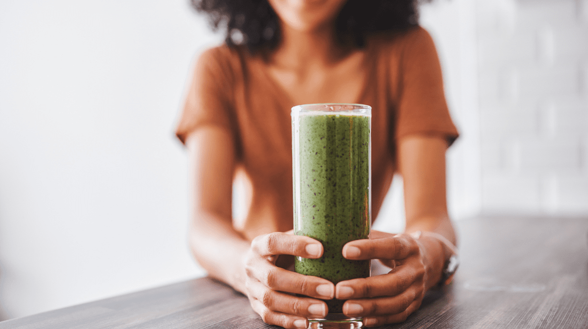 women hold a glass of smoothie
