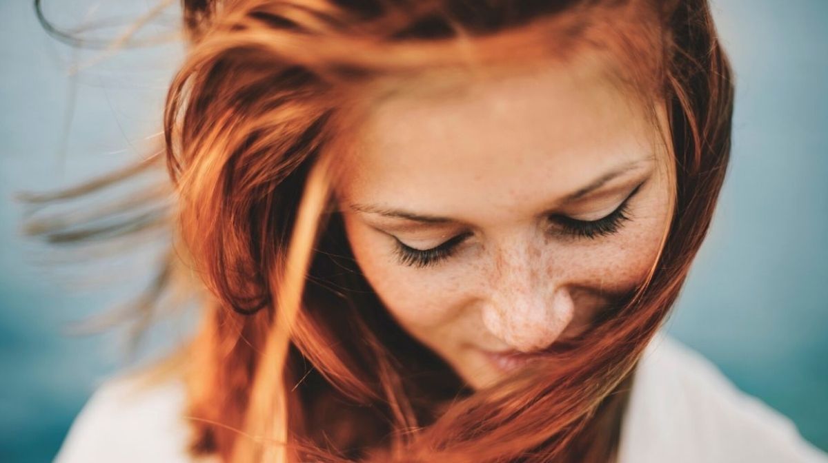 Una giovane donna dai capelli rossi che sorride.