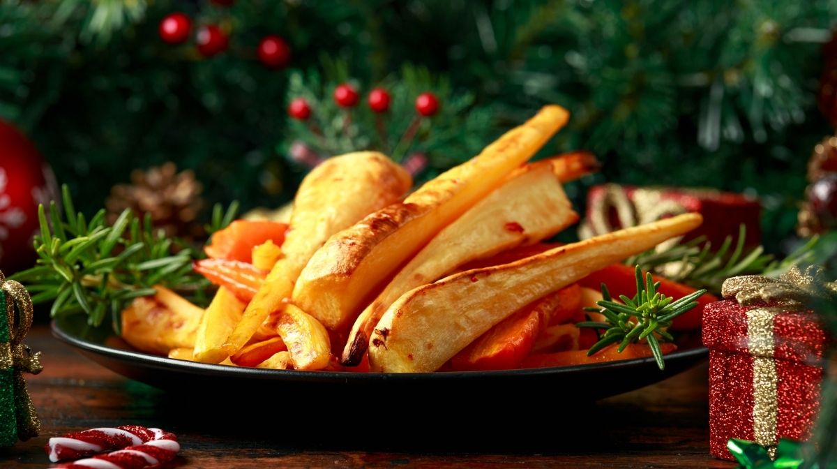 Delizioso cibo vegano su un tavolo di Natale, con un albero decorato sullo sfondo.