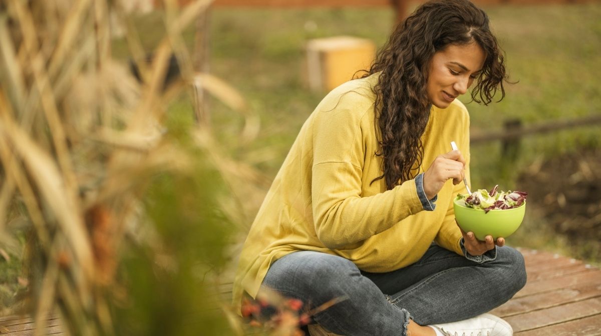 woman eating salad outdoors