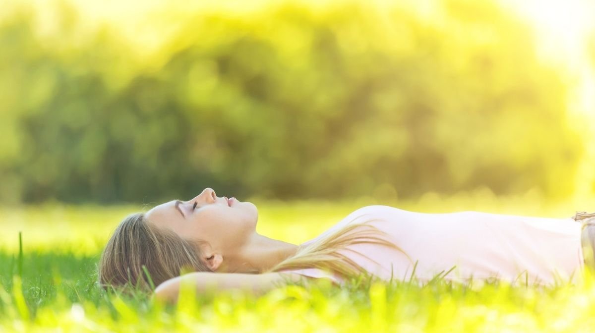 woman sleeping on grass in the sun