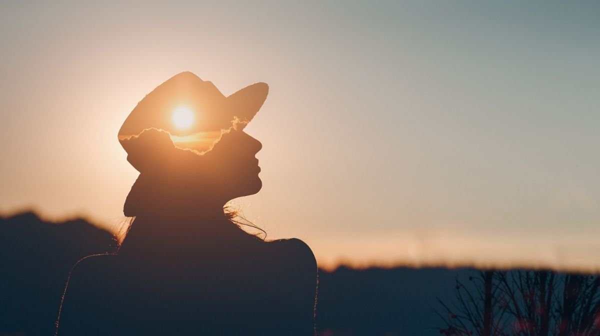 Silhouette of woman looking out into the sunset. 