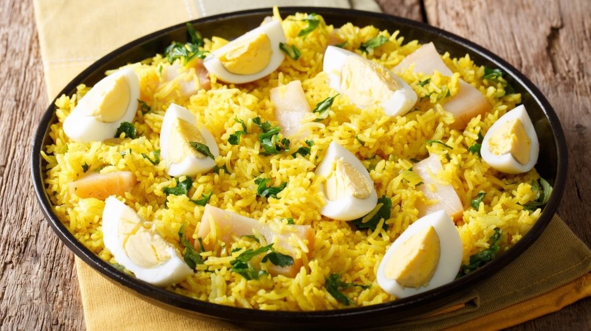 Close-up of Kedgeree food with rice, fish and boiled eggs on a plate.