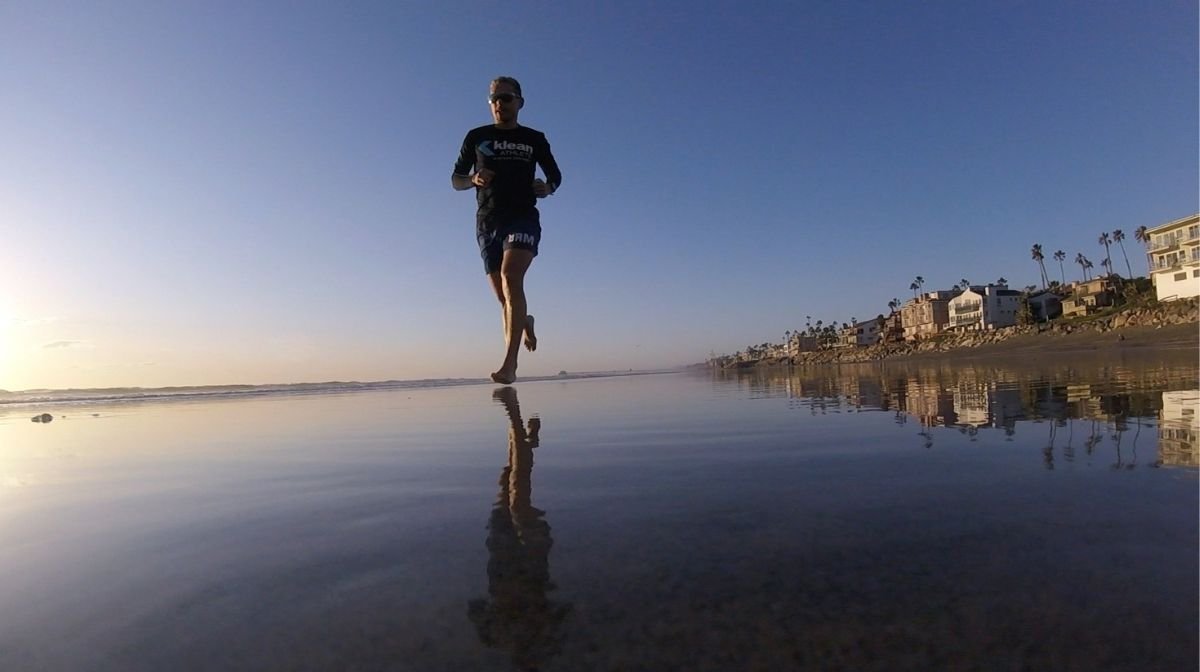 Sponsored Klean Athlete Kevin Portmann running at sunset on the beach