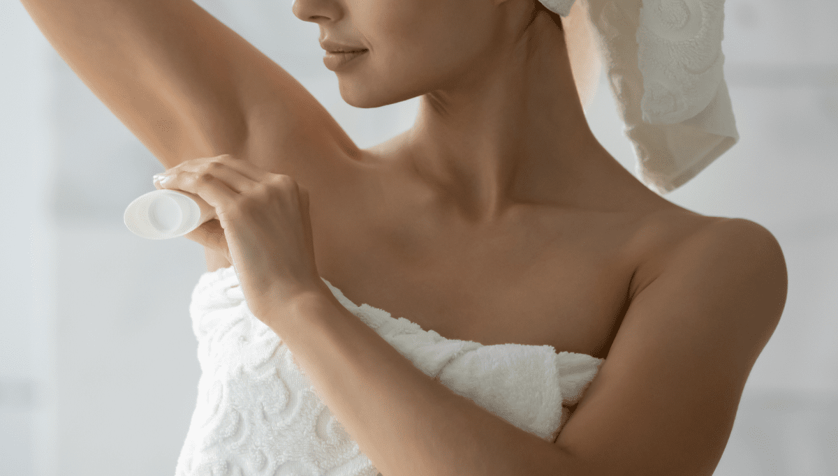 woman applying deodorant in bath towel