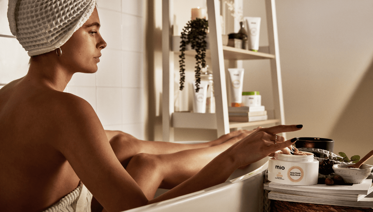 woman in bath with mio solar power body scrub