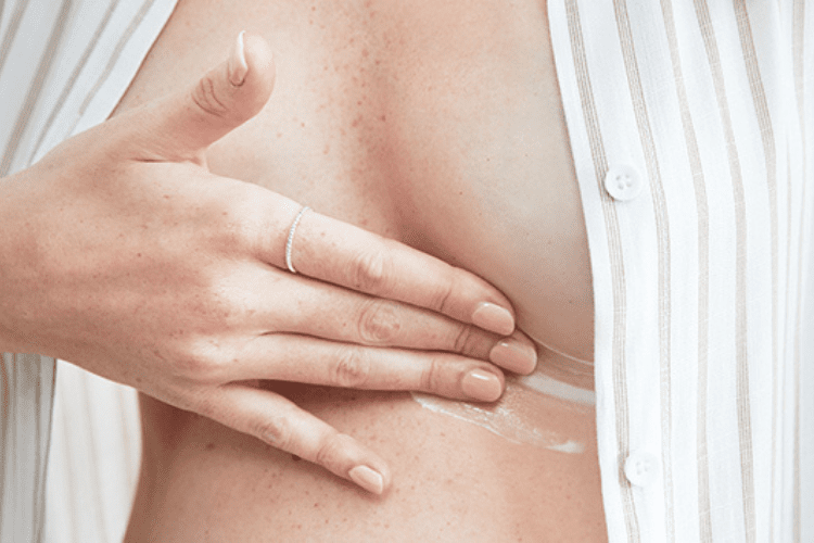 Image of woman applying mama mio pregnancy boob tube to her breasts to help treat mastitis during pregnancy
