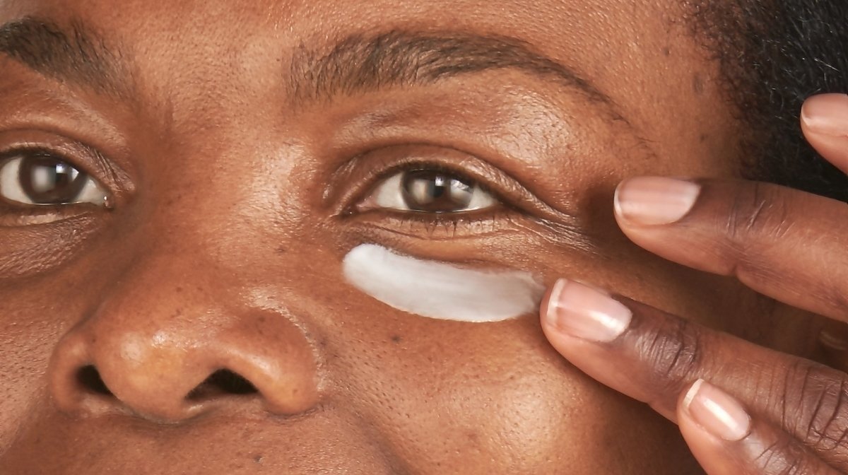 Person applying eye cream to under eyes area
