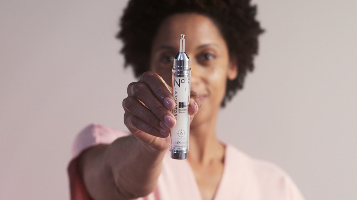 Woman holding LCBS serum out in front of her