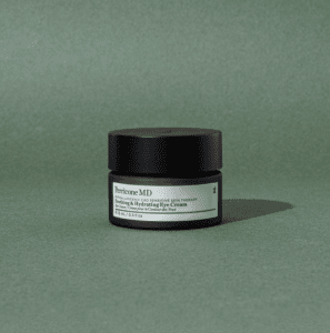 Eye cream tub on a green back drop