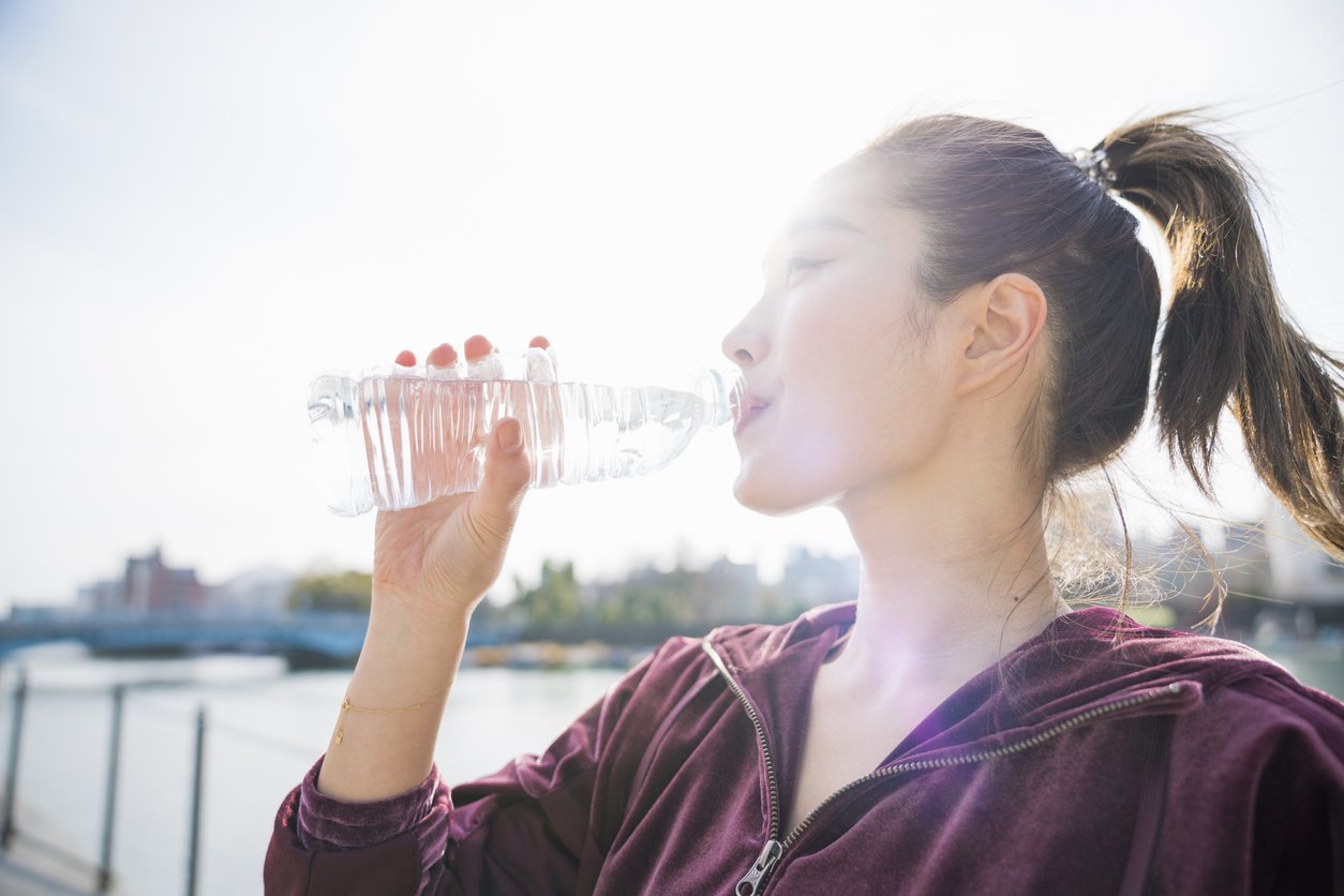 women outside exercising and drinking water