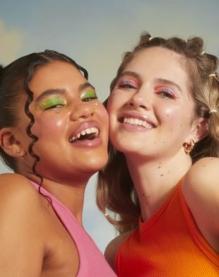 girls wearing bright eyeshadow laughing and smiling